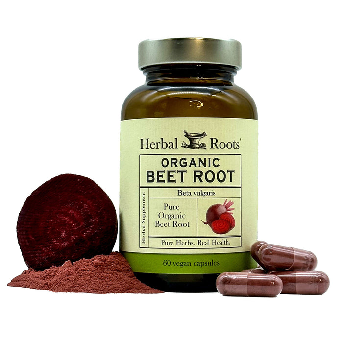 Close up of a bottle of Herbal Roots Organic Beet Root supplement with a few capsules to the front right of the bottle and a small pile of beet root powder with a slice of raw beet root to the left of the bottle
